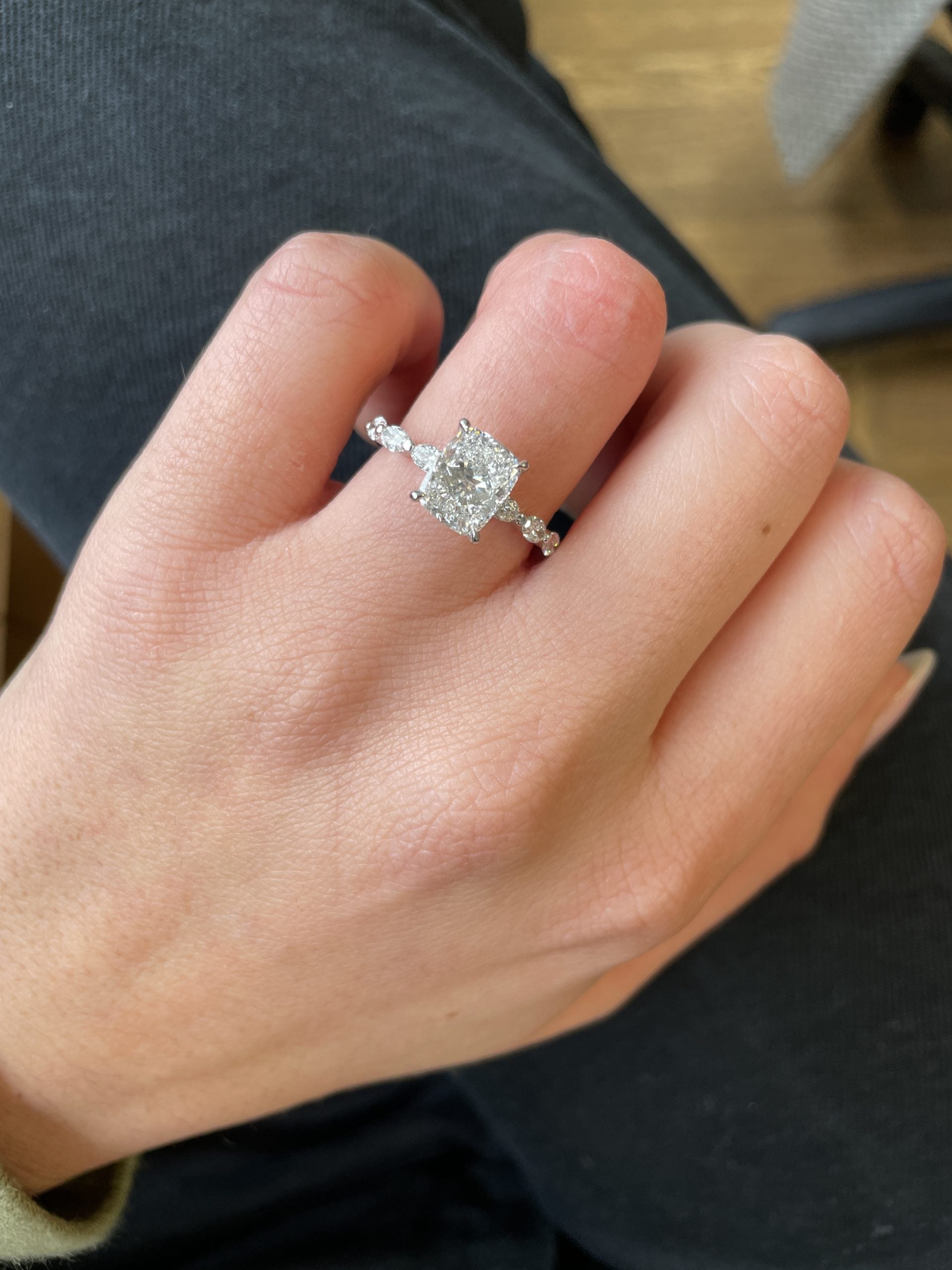 Cushion cut lab grown diamond pavé engagement ring with side stones in prong setting on polished gold band