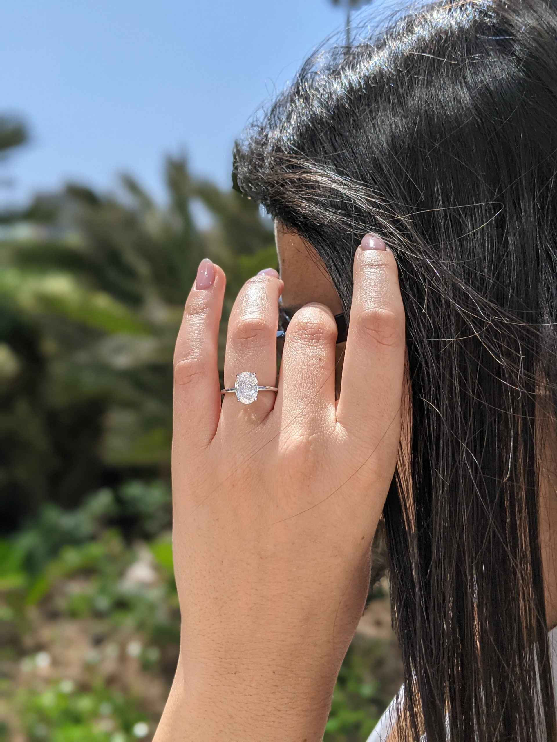 Oval cut lab grown diamond solitaire engagement ring set in classic prong design on polished gold band