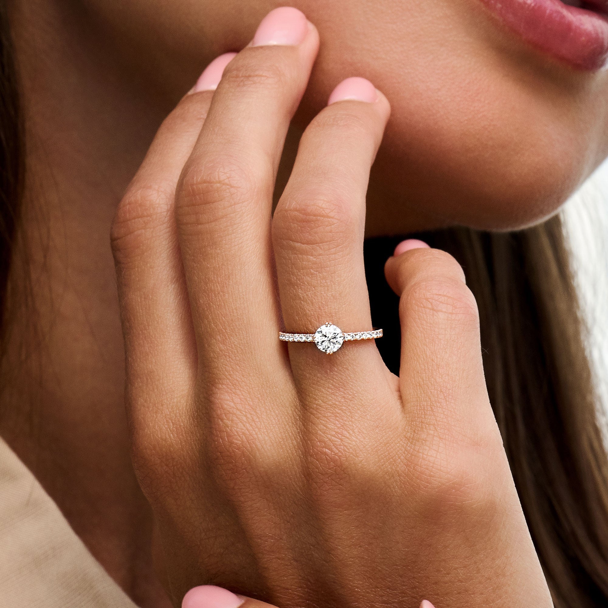 Round cut lab grown diamond pavé engagement ring with side stones set in elegant prong design on polished gold band