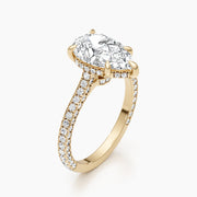 Pear cut lab grown diamond engagement ring with hidden halo and pavé setting on polished gold band