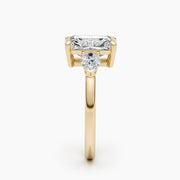 Three stone radiant cut lab grown diamond engagement ring with prong settings on polished gold band, showcasing elegant sparkle