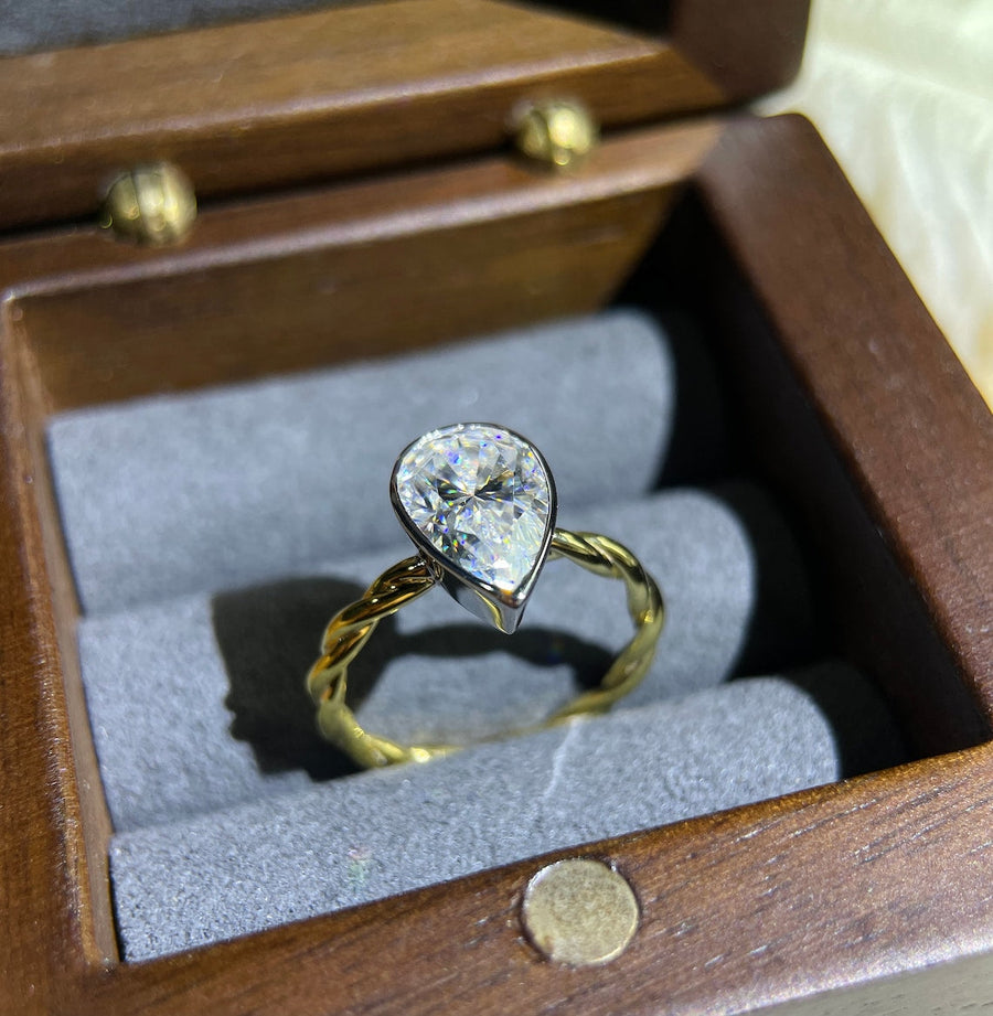 Lab grown diamond engagement ring with pear cut stone in a bezel twisted setting. A unique design that blends modern artistry with timeless romance.