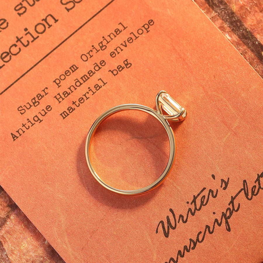 Emerald cut lab grown diamond solitaire engagement ring set in a classic prong design on polished gold band