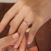 Emerald cut lab grown diamond solitaire engagement ring set in a classic prong design on polished gold band