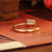 Emerald cut lab grown diamond solitaire engagement ring set in a classic prong design on polished gold band