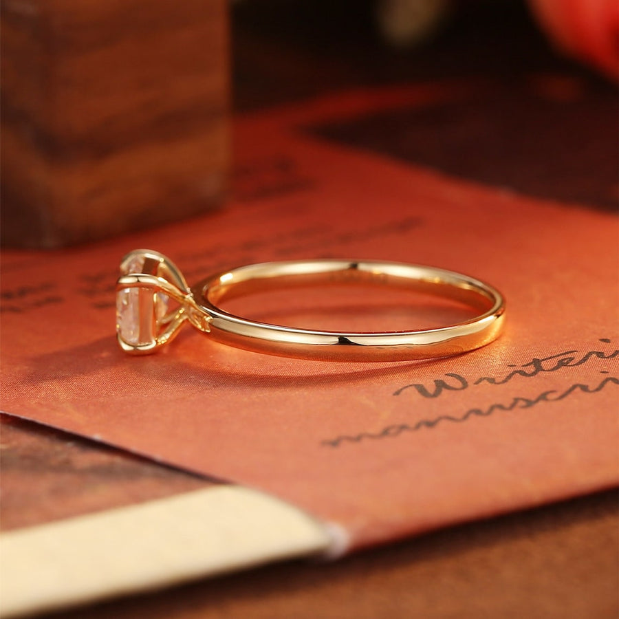 Emerald cut lab grown diamond solitaire engagement ring set in a classic prong design on polished gold band