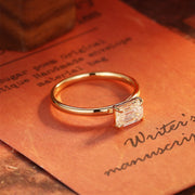 Emerald cut lab grown diamond solitaire engagement ring set in a classic prong design on polished gold band