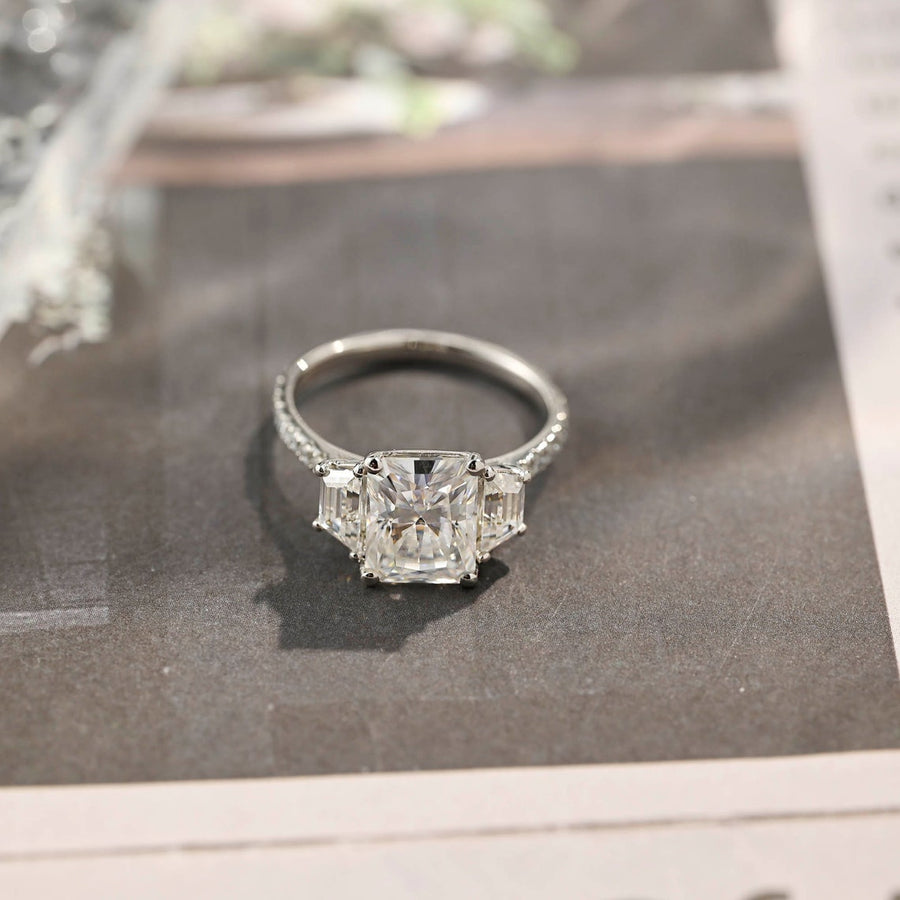 Radiant cut lab grown diamond three stone engagement ring with prong setting on polished gold band