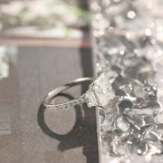 Radiant cut lab grown diamond three stone engagement ring with prong setting on polished gold band