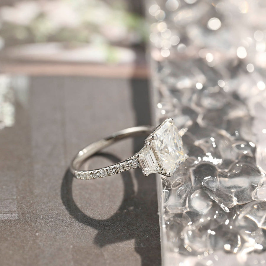 Radiant cut lab grown diamond three stone engagement ring with prong setting on polished gold band