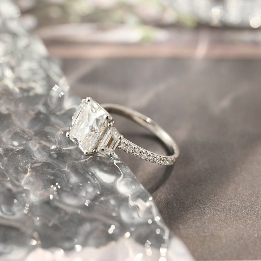 Radiant cut lab grown diamond three stone engagement ring with prong setting on polished gold band