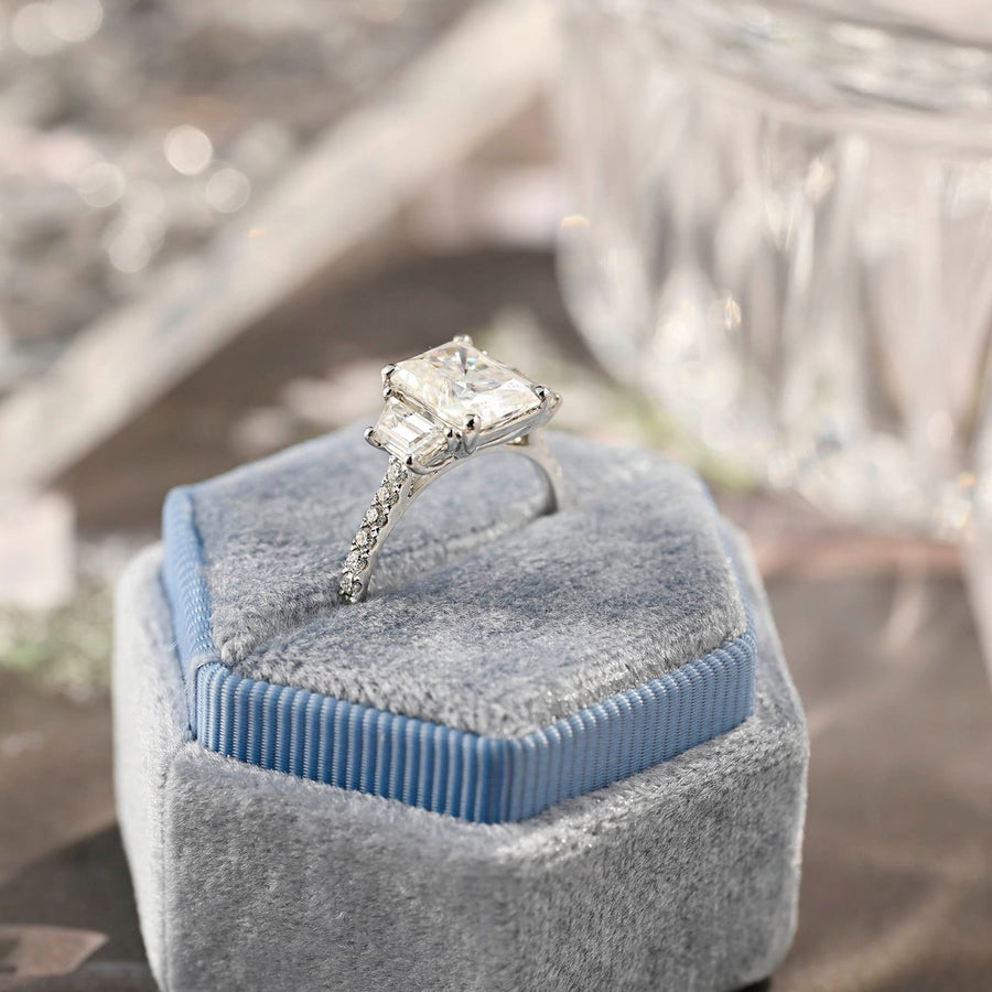 Radiant cut lab grown diamond three stone engagement ring with prong setting on polished gold band