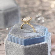 Radiant cut lab grown diamond hidden halo pavé engagement ring with side stones, set in polished gold band