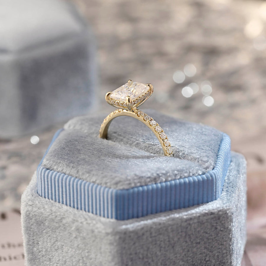Radiant cut lab grown diamond hidden halo pavé engagement ring with side stones, set in polished gold band