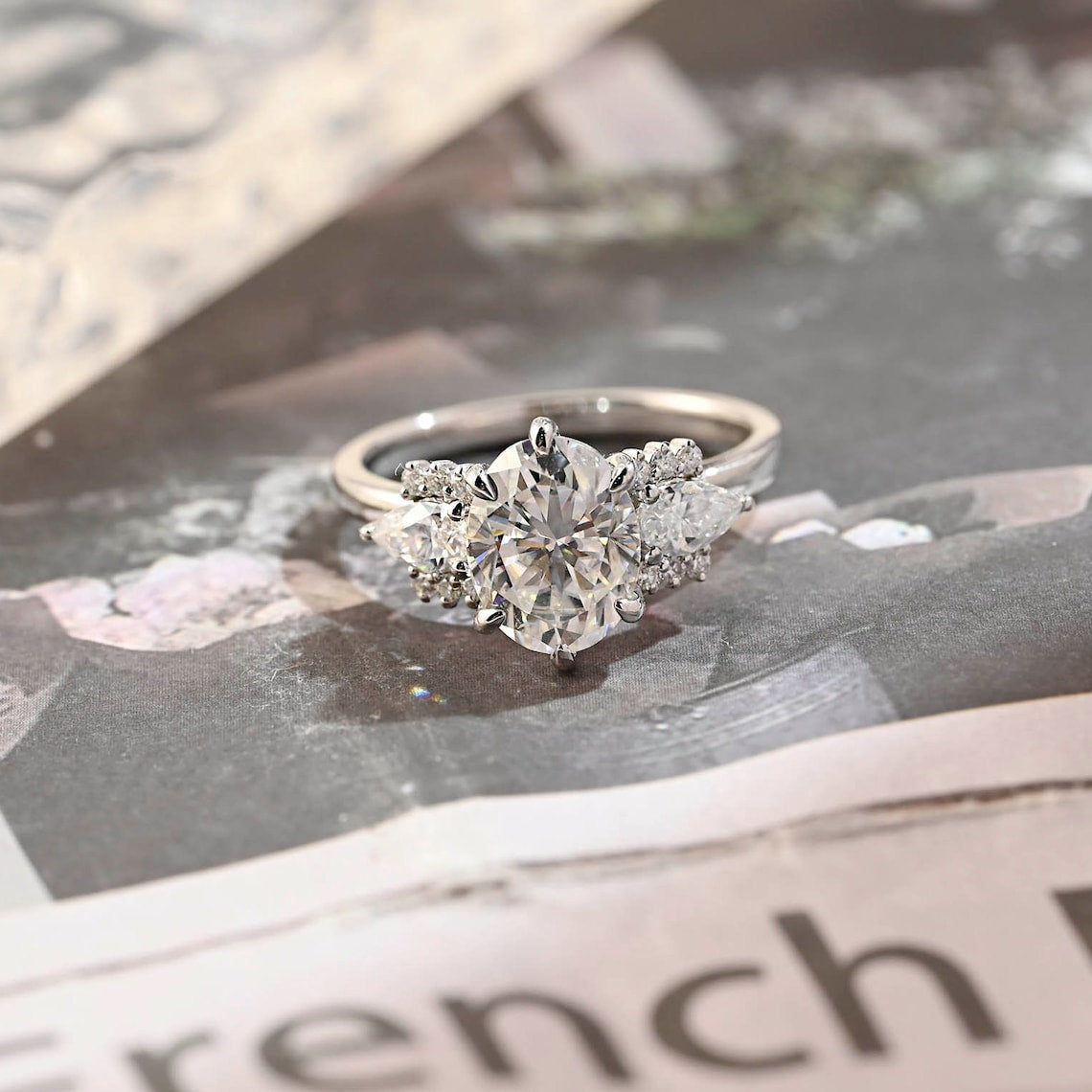 Oval cut lab grown diamond cluster engagement ring with side stones in elegant prong setting on polished gold band