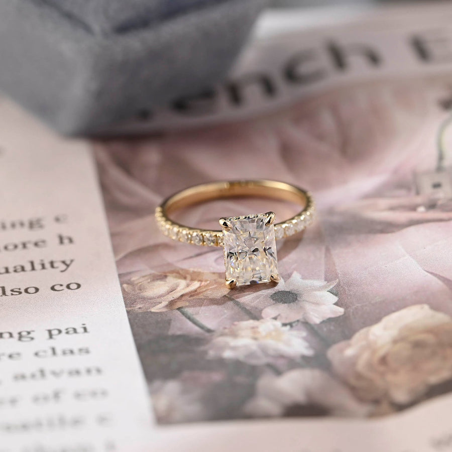 Radiant cut lab grown diamond hidden halo pavé engagement ring with side stones, set in polished gold band