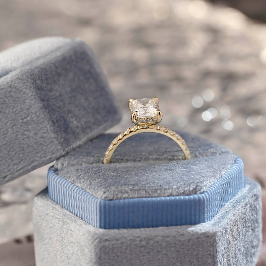 Radiant cut lab grown diamond hidden halo pavé engagement ring with side stones, set in polished gold band