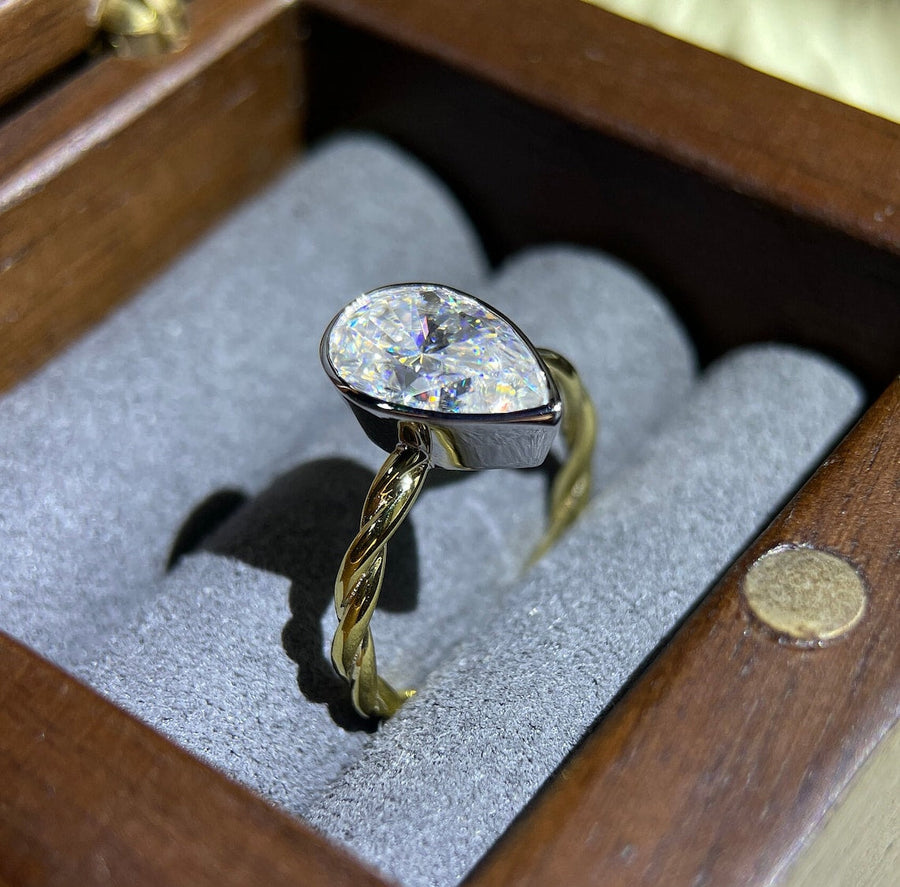 Lab grown diamond engagement ring with pear cut stone in a bezel twisted setting. A unique design that blends modern artistry with timeless romance.