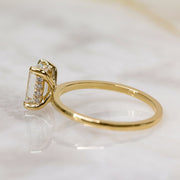 Emerald cut lab grown diamond hidden halo engagement ring with delicate prong setting and polished gold band