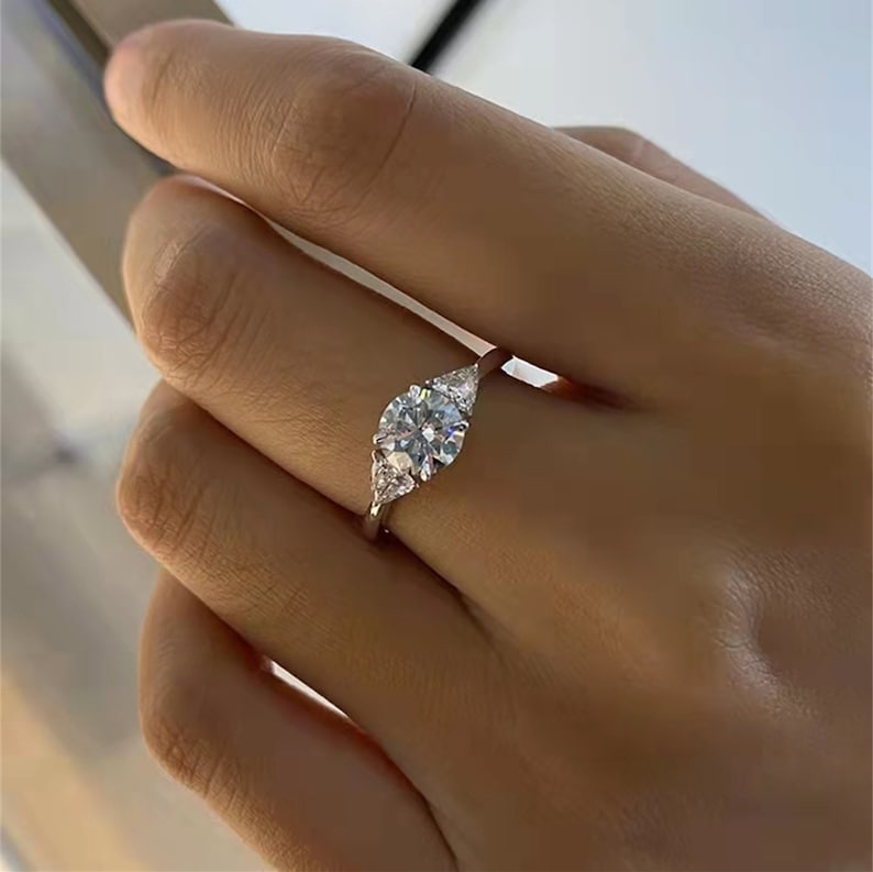 Round cut lab grown diamond three stone engagement ring with prong setting, symbolizing past, present, and future love