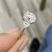 Round cut lab grown diamond three stone engagement ring with prong setting, symbolizing past, present, and future love