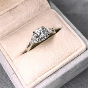 Round cut lab grown diamond three stone engagement ring with prong setting, symbolizing past, present, and future love