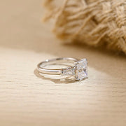 Radiant cut lab grown diamond three stone engagement ring with side stones in elegant prong setting on polished gold band