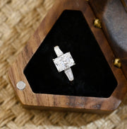Radiant cut lab grown diamond three stone engagement ring with side stones in elegant prong setting on polished gold band