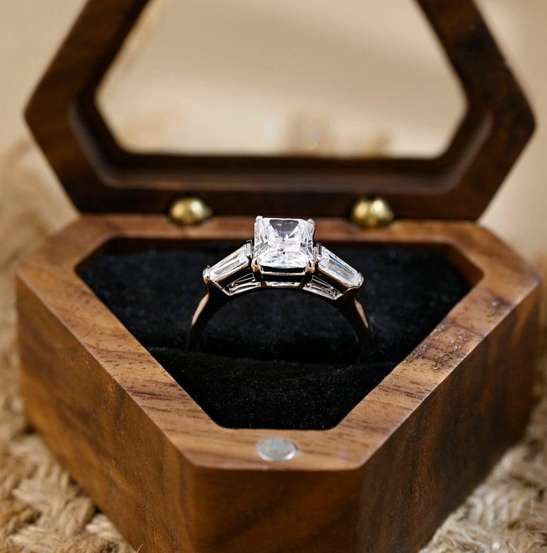 Radiant cut lab grown diamond three stone engagement ring with side stones in elegant prong setting on polished gold band