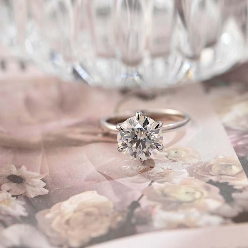 Round cut lab grown diamond hidden halo solitaire engagement ring with prong setting on polished gold band