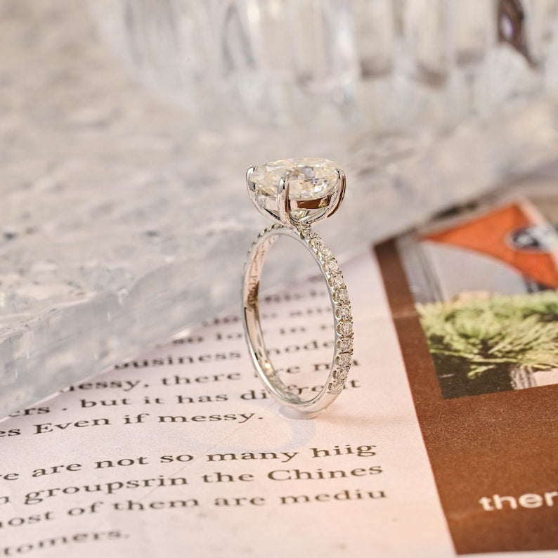 Oval cut lab grown diamond halo pavé engagement ring with side stones, set in prong design on polished gold band