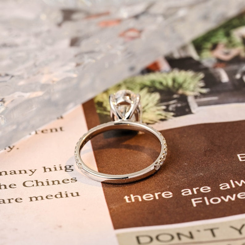 Oval cut lab grown diamond halo pavé engagement ring with side stones, set in prong design on polished gold band