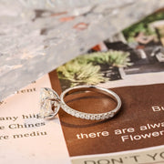 Oval cut lab grown diamond halo pavé engagement ring with side stones, set in prong design on polished gold band