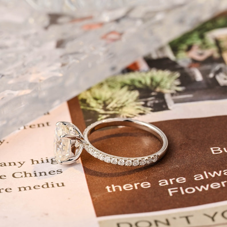 Oval cut lab grown diamond halo pavé engagement ring with side stones, set in prong design on polished gold band