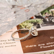 Oval cut lab grown diamond halo pavé engagement ring with side stones, set in prong design on polished gold band