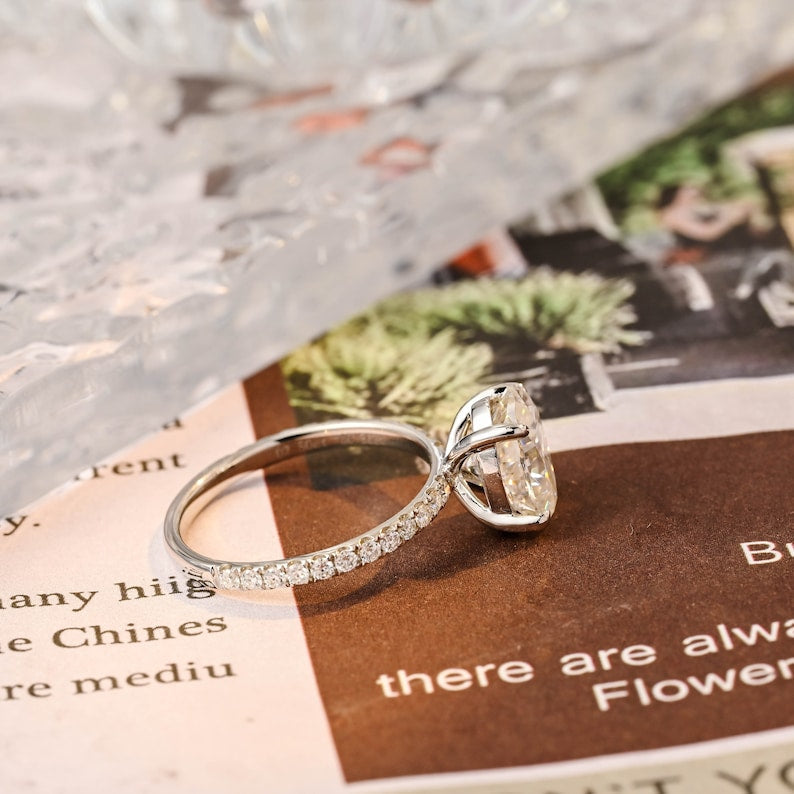 Oval cut lab grown diamond halo pavé engagement ring with side stones, set in prong design on polished gold band