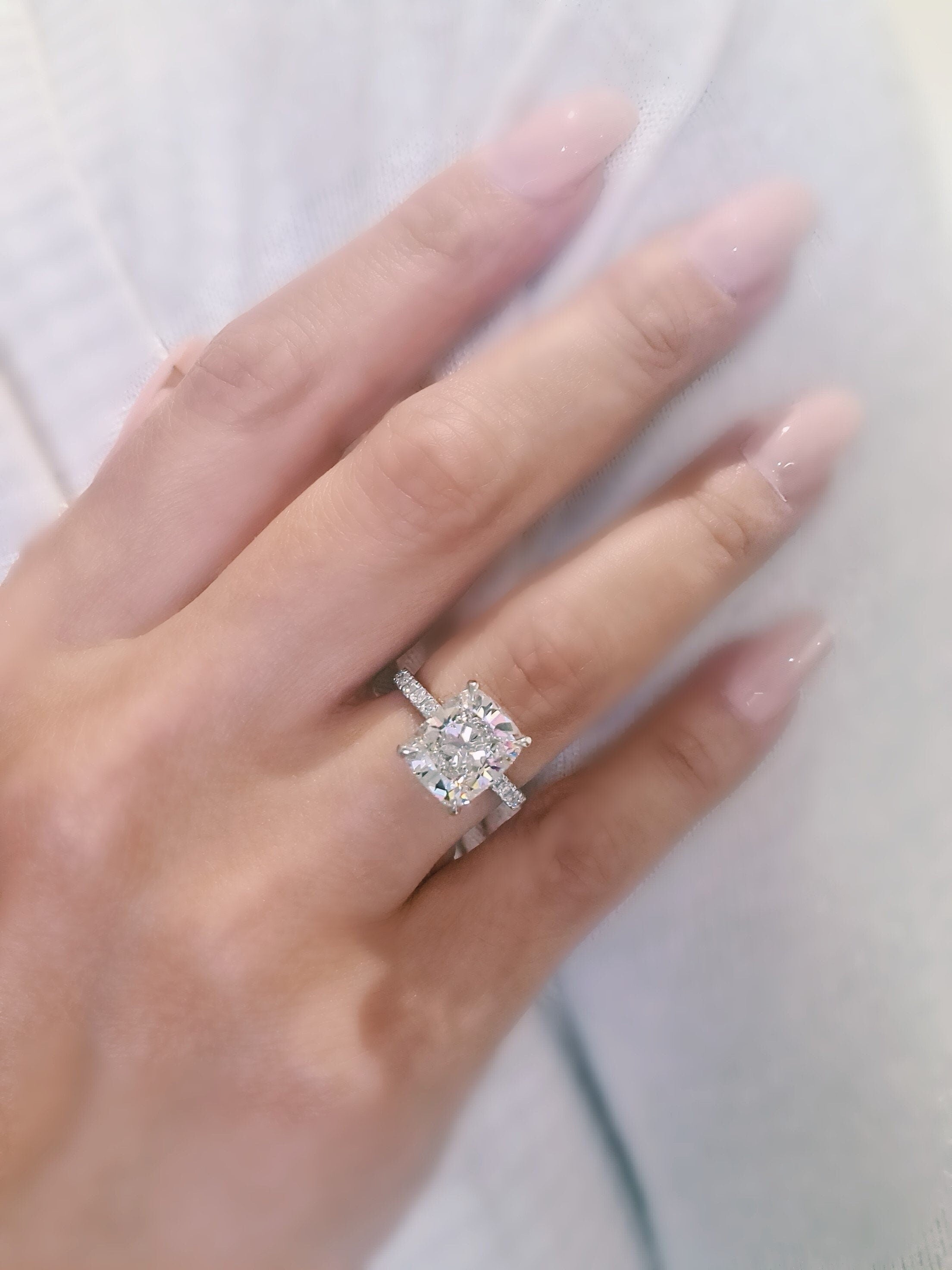 Cushion cut lab grown diamond engagement ring with pavé setting, featuring a sparkling center stone on a polished gold band