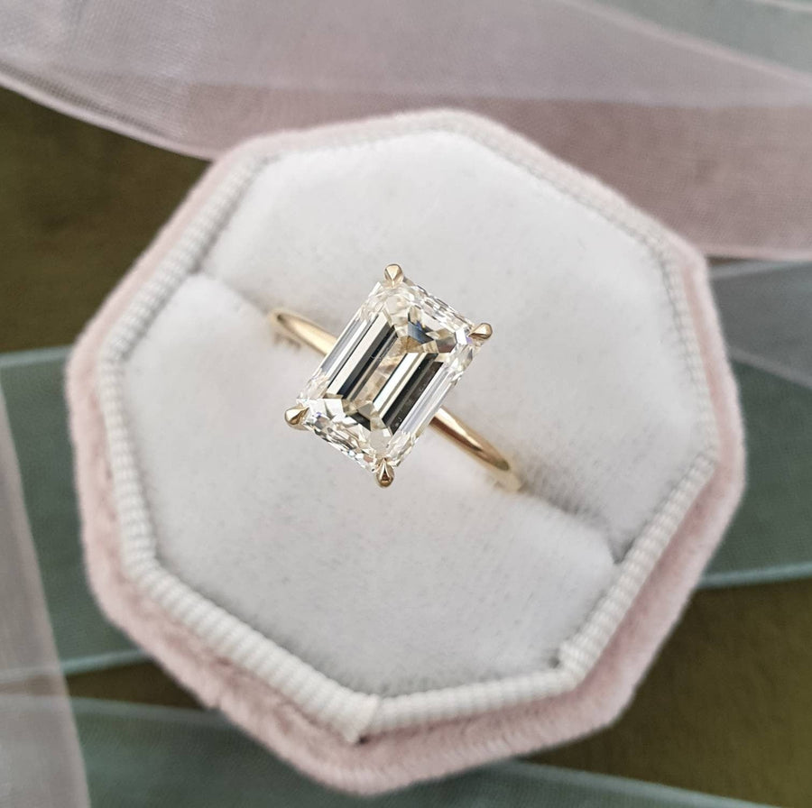 Emerald cut lab grown diamond engagement ring with hidden halo setting, crafted in polished gold for a refined and elegant look