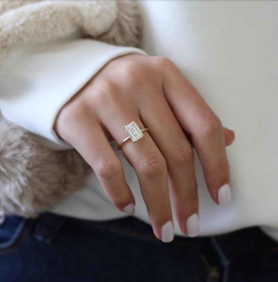 Emerald cut lab grown diamond engagement ring with hidden halo setting, crafted in polished gold for a refined and elegant look