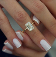Emerald cut lab grown diamond engagement ring with hidden halo setting, crafted in polished gold for a refined and elegant look