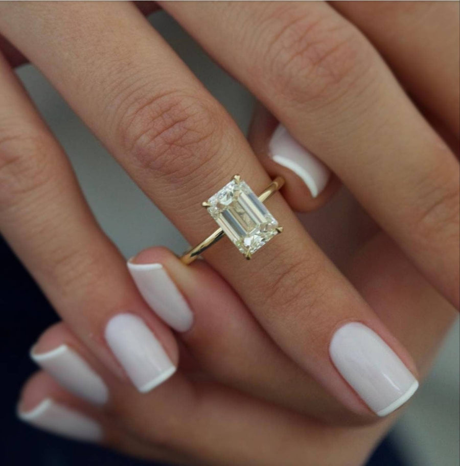 Emerald cut lab grown diamond engagement ring with hidden halo setting, crafted in polished gold for a refined and elegant look