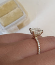 Radiant cut lab grown diamond pavé engagement ring with sparkling side stones set on polished gold band in prong setting