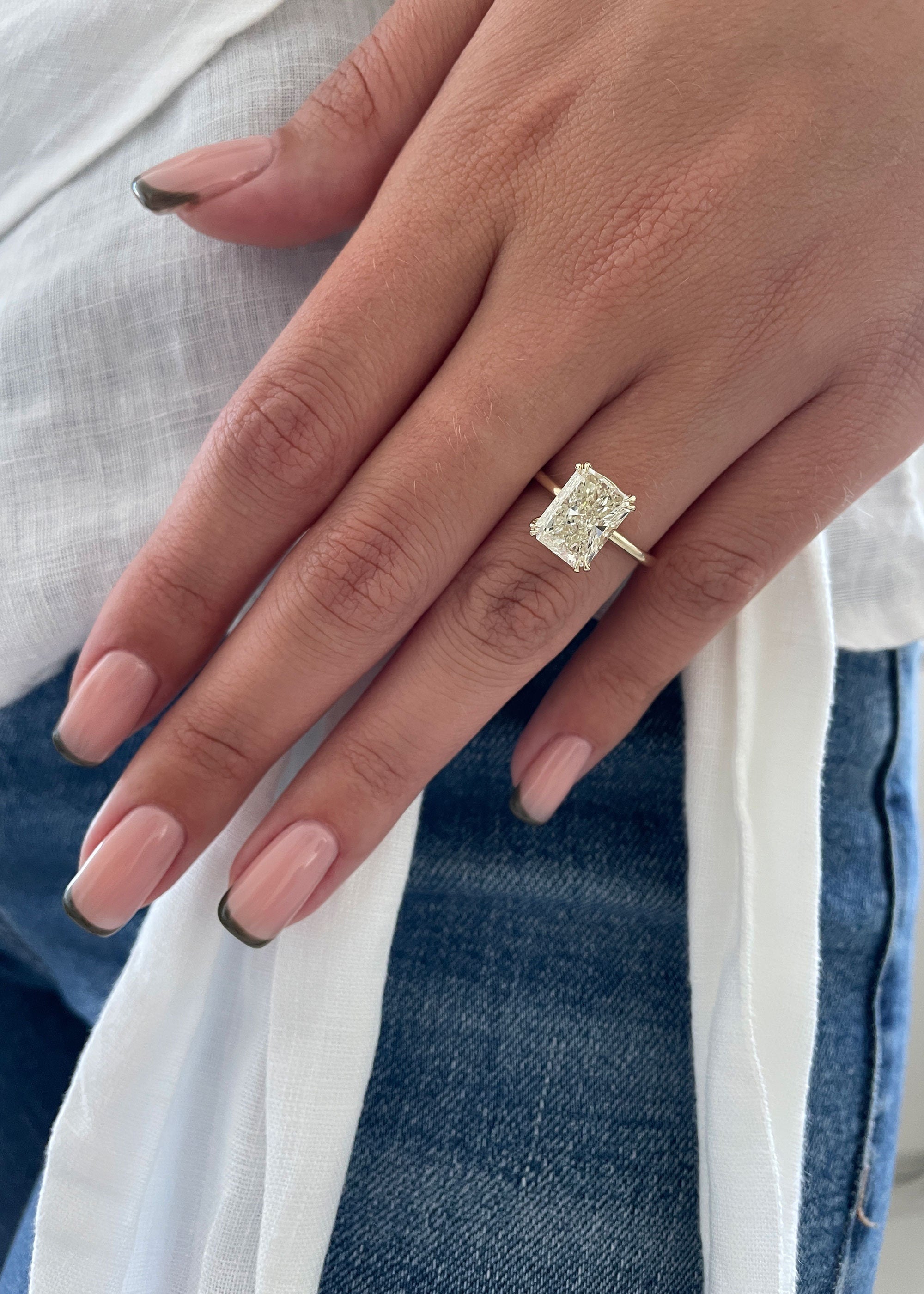 Radiant cut lab grown diamond solitaire engagement ring in classic prong setting on polished gold band