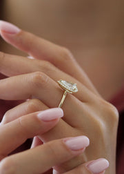 Pear cut lab grown diamond engagement ring with halo setting, featuring accent stones on a polished gold band