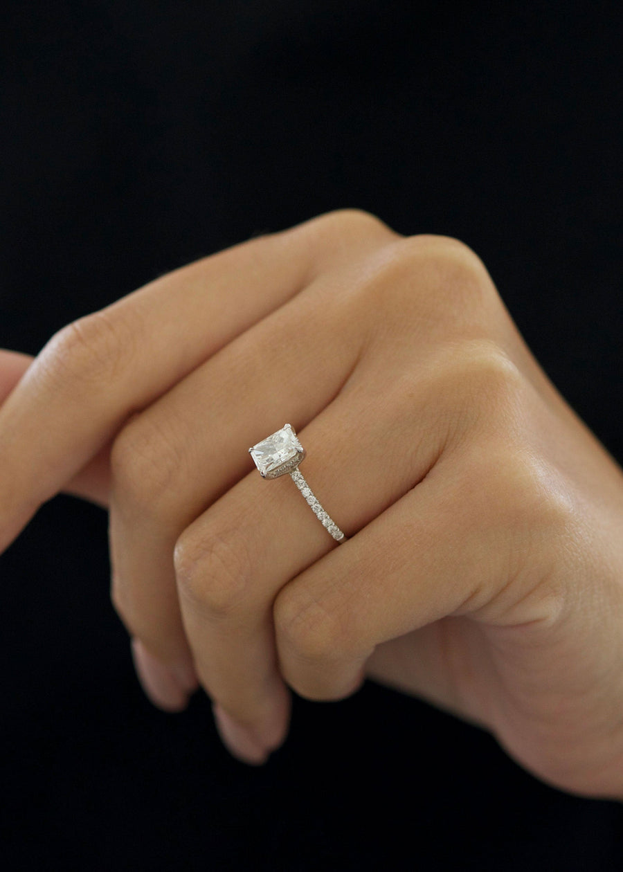 Radiant cut lab grown diamond pavé engagement ring with side stones set in polished gold band in classic prong setting