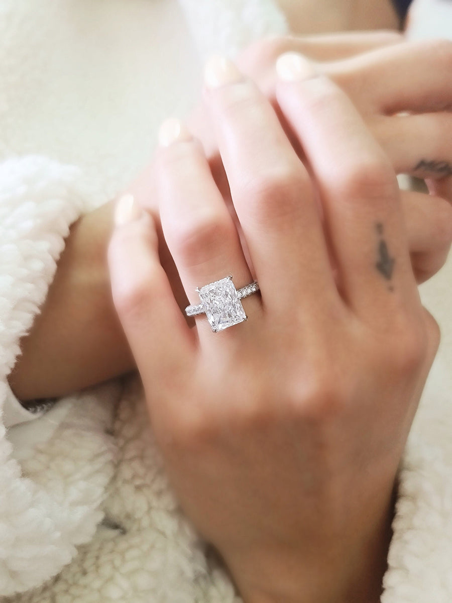 Radiant cut lab grown diamond engagement ring with hidden halo setting on polished gold band, creating extra sparkle and elegance