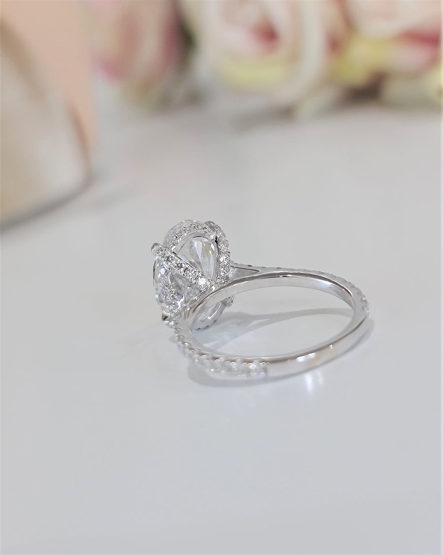 Oval cut lab grown diamond hidden halo engagement ring with delicate pavé accents set in polished gold band