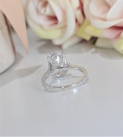 Oval cut lab grown diamond hidden halo engagement ring with delicate pavé accents set in polished gold band