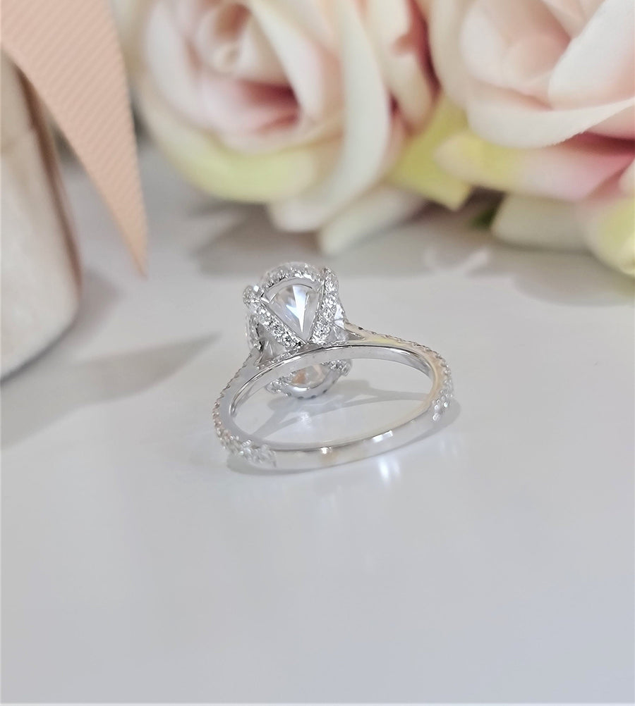 Oval cut lab grown diamond hidden halo engagement ring with delicate pavé accents set in polished gold band