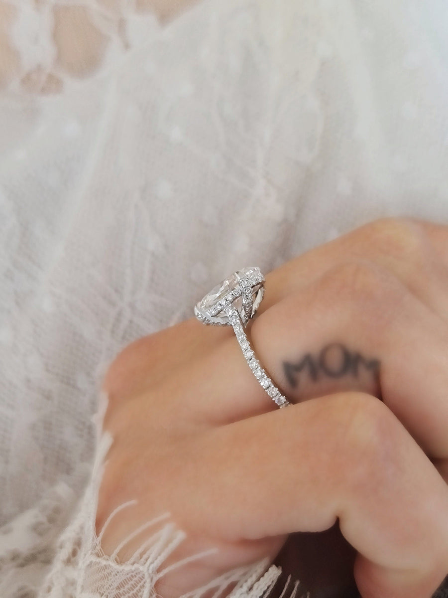 Oval cut lab grown diamond hidden halo engagement ring with delicate pavé accents set in polished gold band